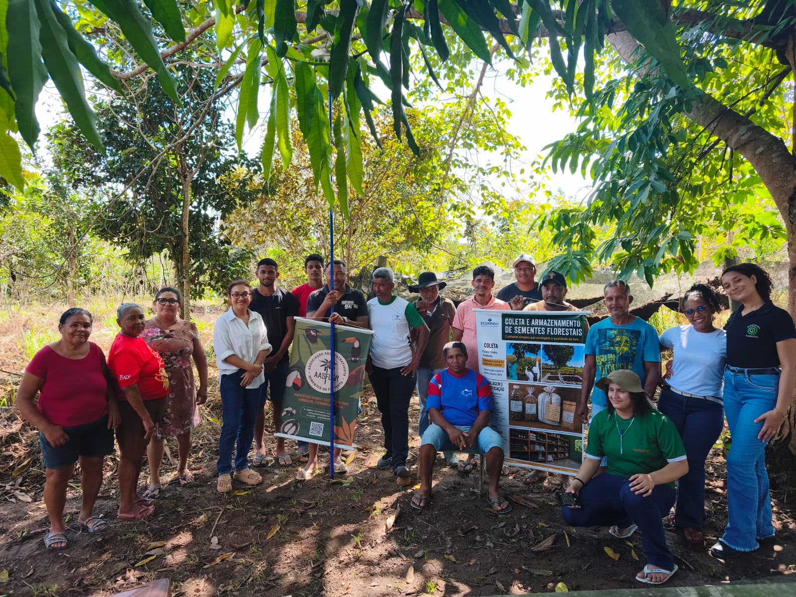 Participantes da oficina de sementes florestais reunidos com o banner da AASFLOR